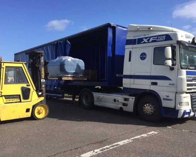 A lorry trailer being loaded with machinery